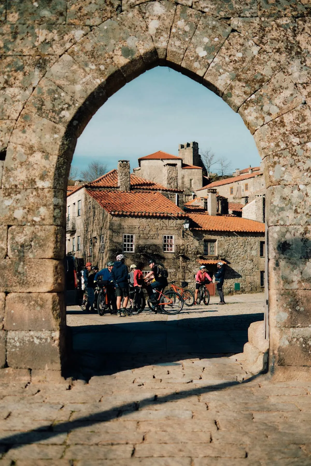 Arch showing village in coa valley, portugal with cyclists.