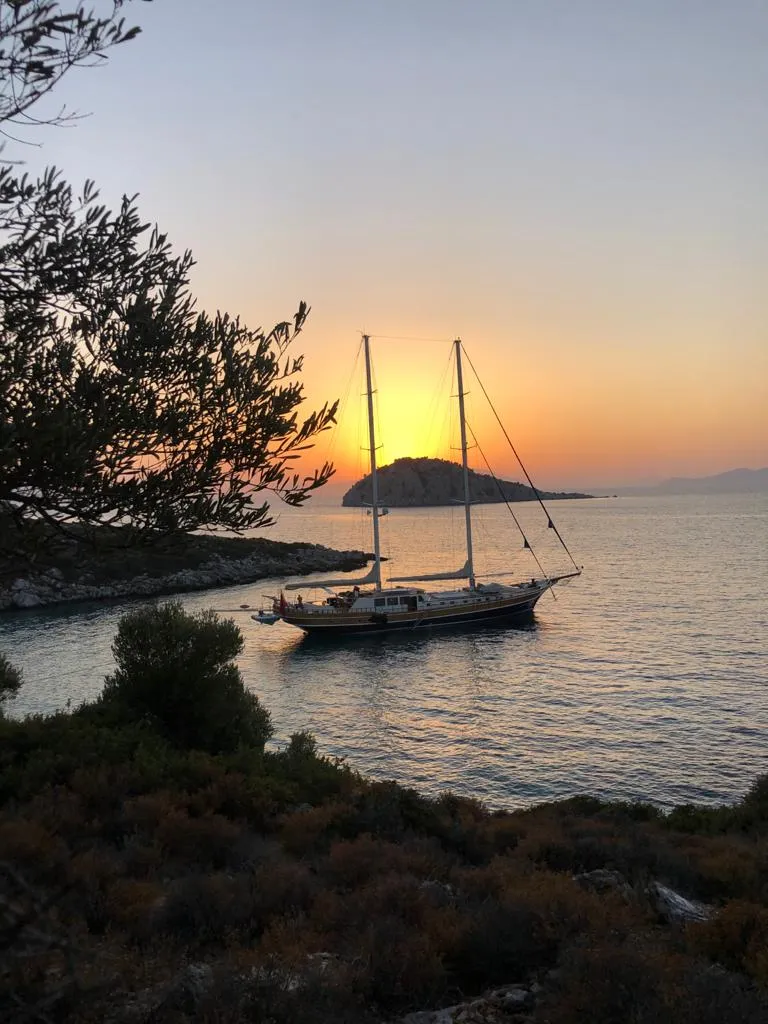 A traditional Turkish gulet boat set against the sunset in the Dodecanese Islands