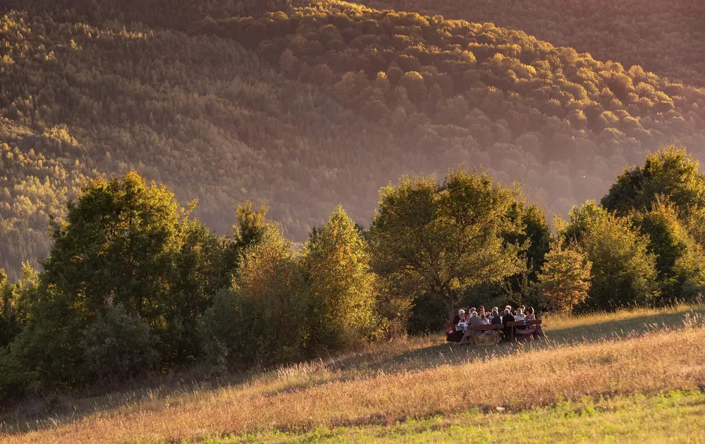 Guests enjoy a picnic in a field near King Charles's guest house in Zalanpatak, Transylvania