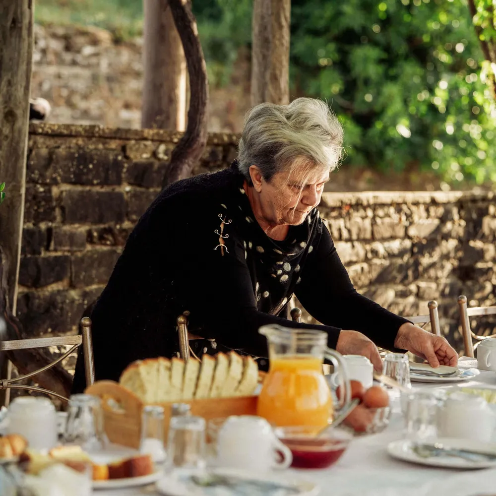 A guest house owner preparing breakfast for Slow Cyclists in Zagori, Greece.