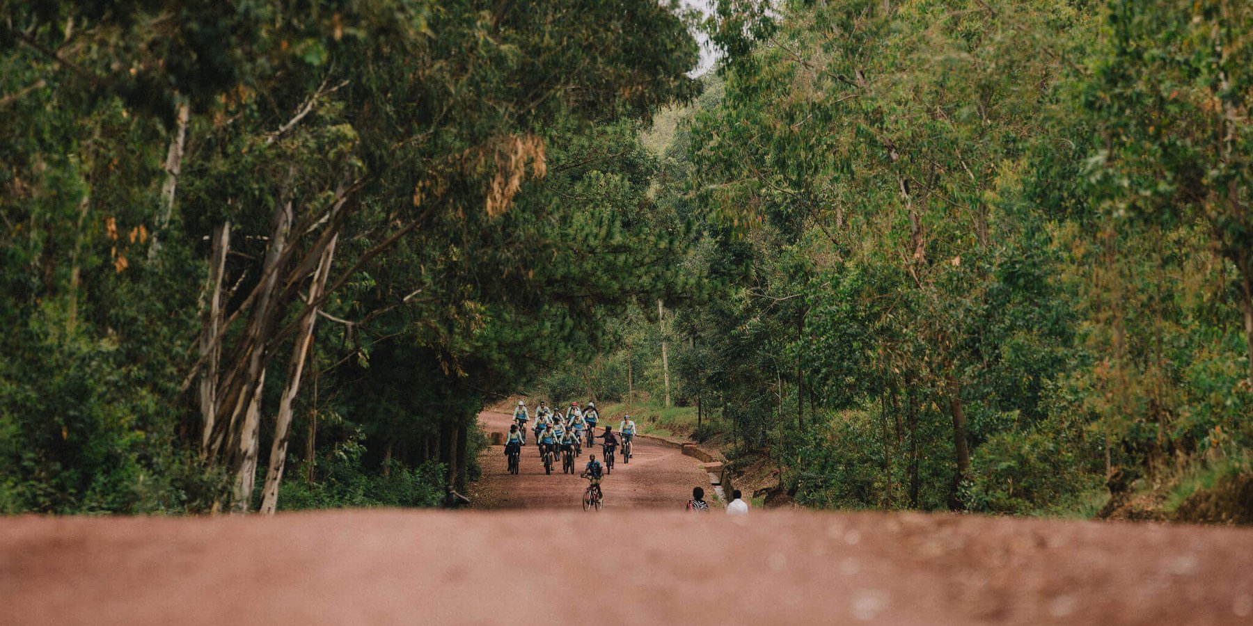 A group of slow cyclists on the red roads of Northern Rwanda