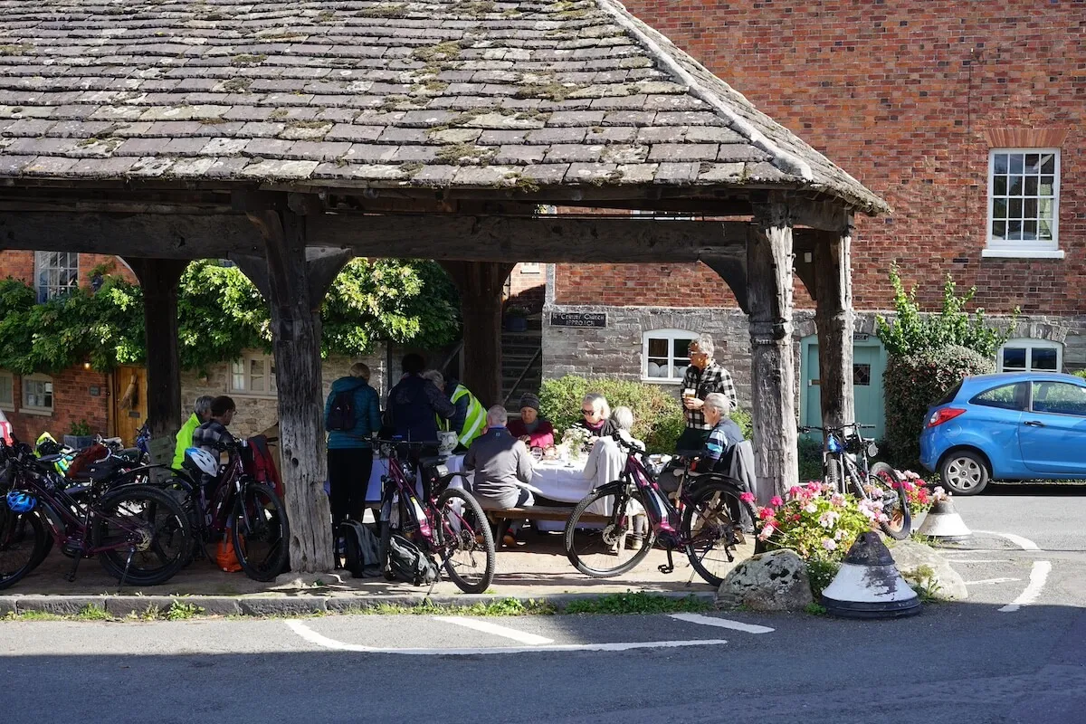 Cyclists enjoying lunch in traditional village, Herefordshire, UK
