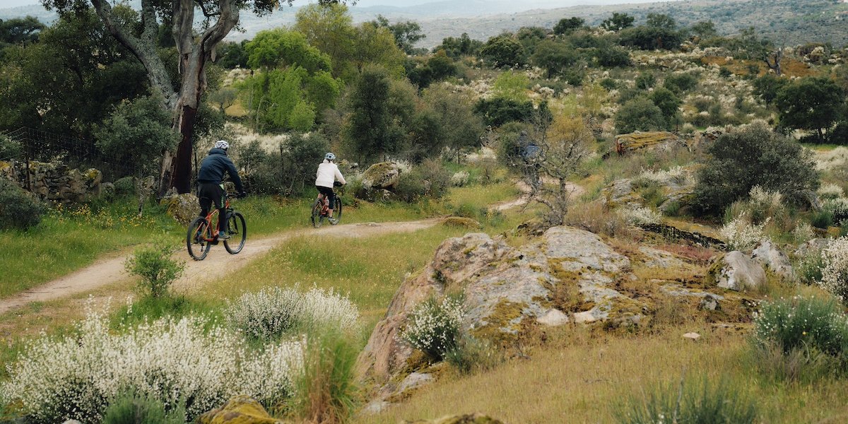 Cyclists on small track through wildnerness, in Coa Valley, Portugal
