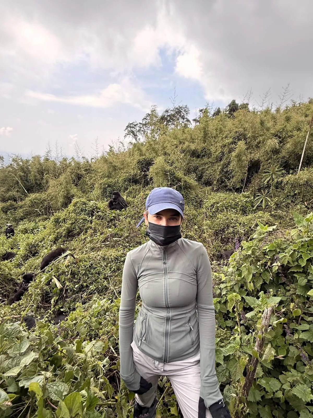 Emelye in a mask to avoid the spread of illness while gorilla trekking in Rwanda