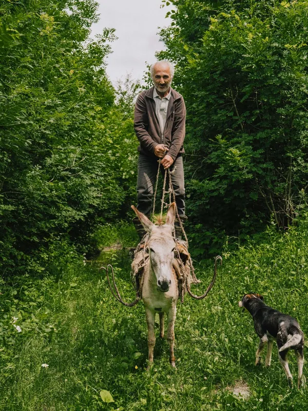 A farmer standing on his donkey in the Armenian Highlands, where Slow Cyclists explore