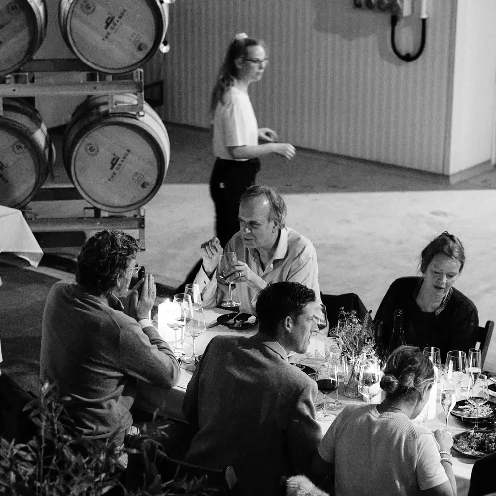 Guests eating food from Imad's Syran Kitchen among wine barrels at The Grange at The Slow Table event