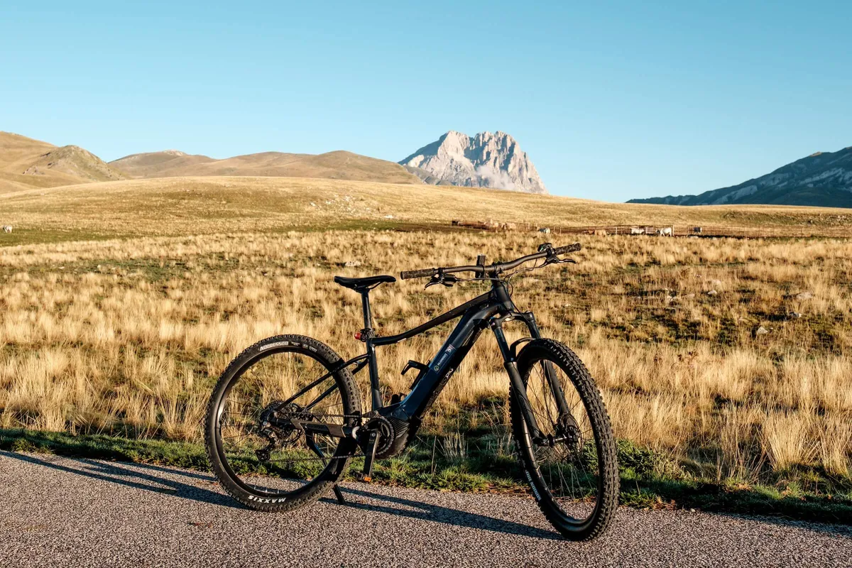 Cyclists on road with mountain backdrop, Campo Imperatore, Abruzzo. Italy