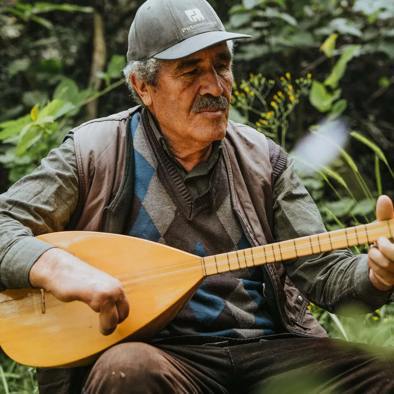 A man playing a traditional Turkish string instrument for Slow Cyclist guests in the Taurus Mountains.