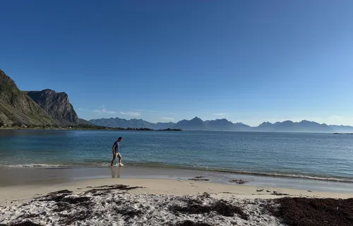 Man on beach, mountain background, Hadseloya Island, Norway