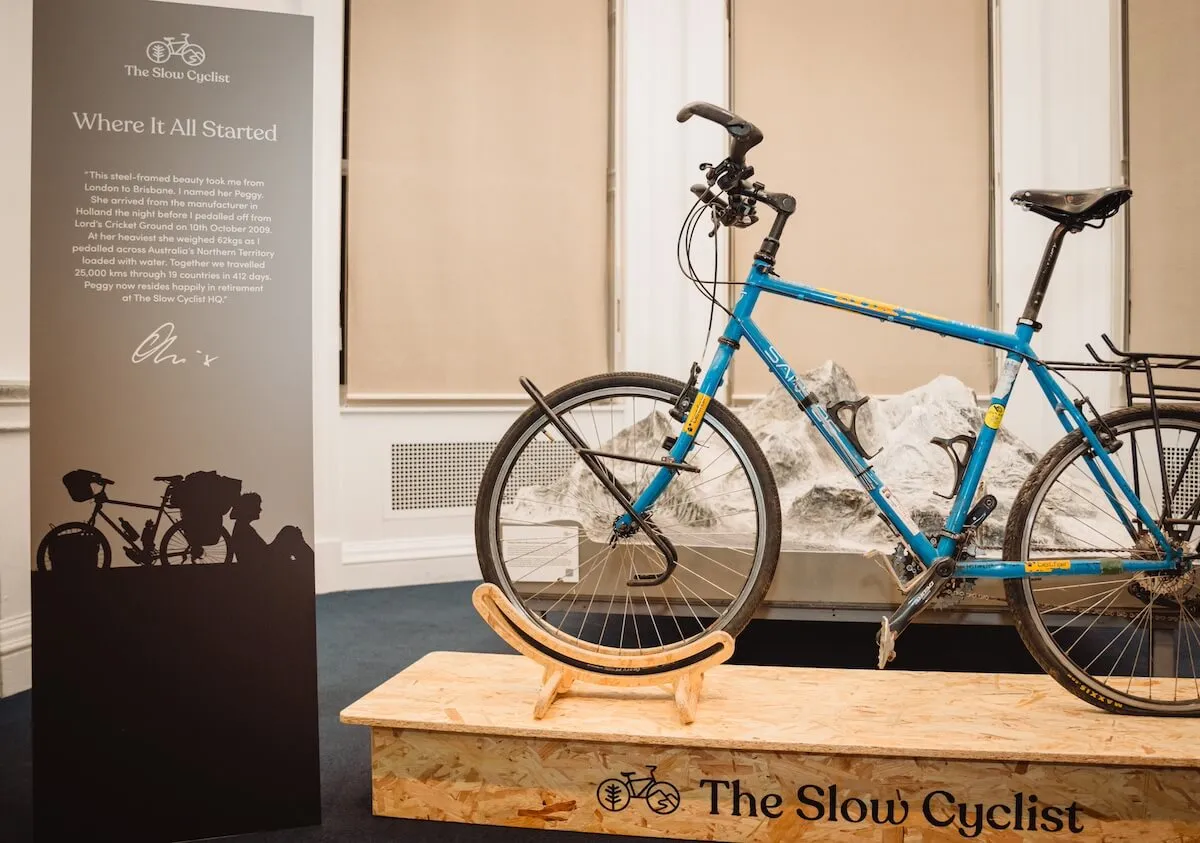 Oli bike on wooden plinth in front of sign - 10 yr party where it all started