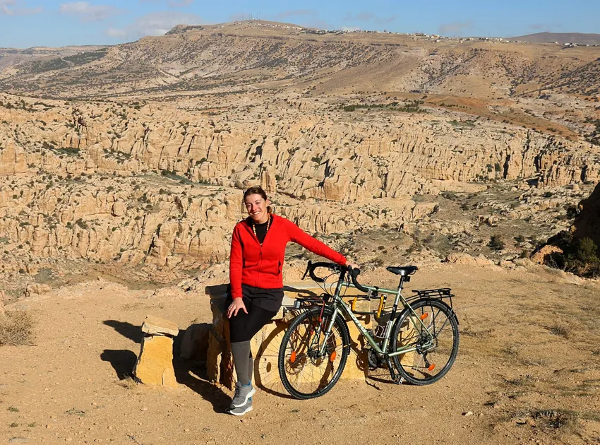 Rebecca Lowe on her bike Maud against a mountainous landscape