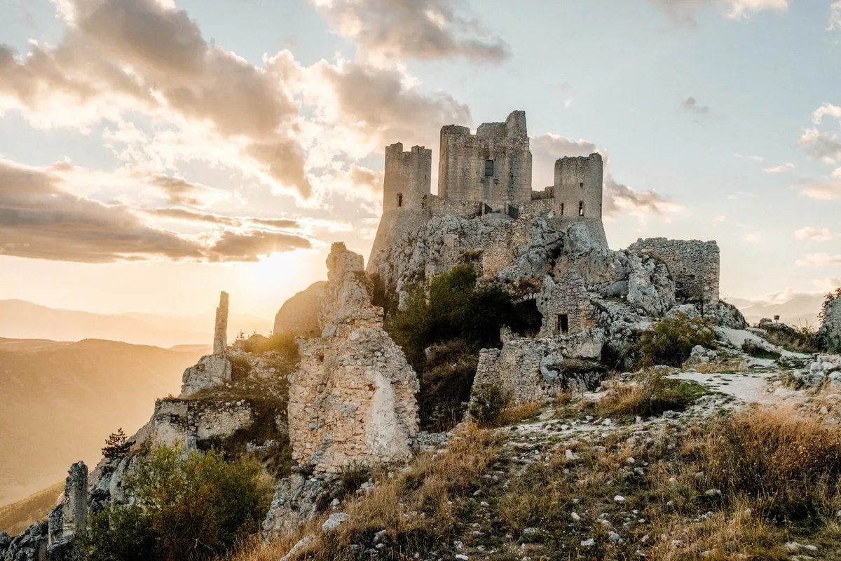 Ruins of Castel of Rocca Calascio on the hillside at sunset, Abruzzo, Italy