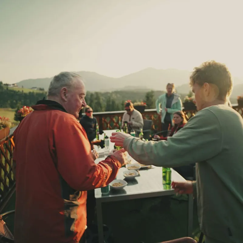 Wild Lines guests enjoying a beer with a view across the hills of Bucovina after a day of walking the Via Transilvanica trail.