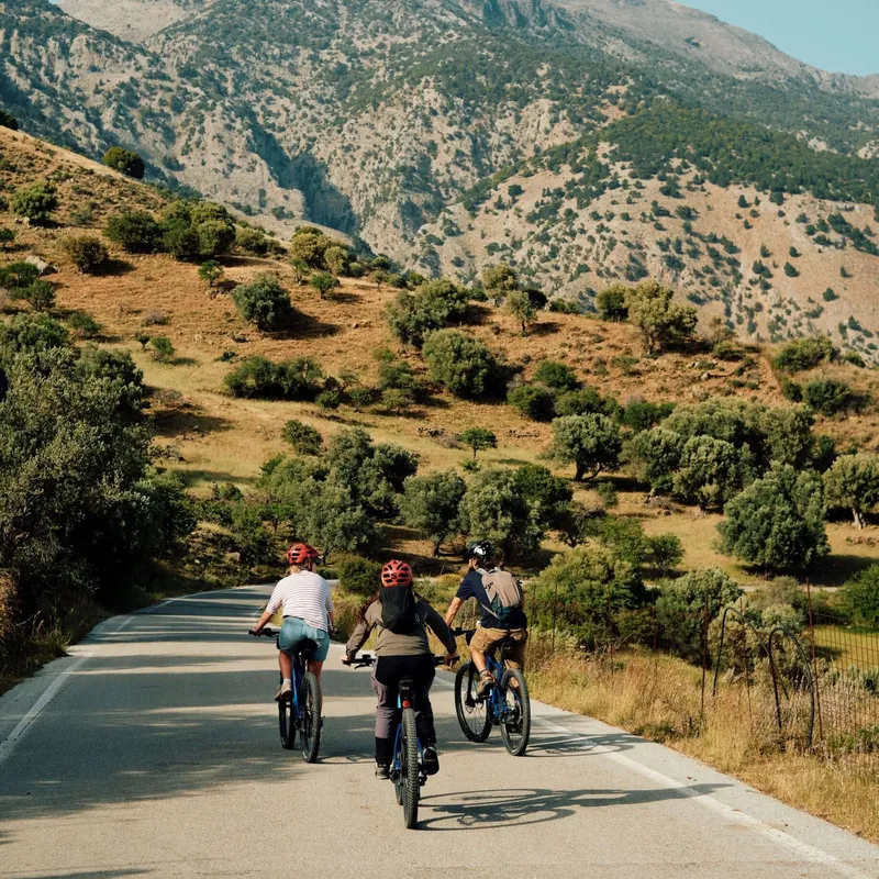 Three Slow Cyclists riding through the mountains on electric bikes in Crete, Greece