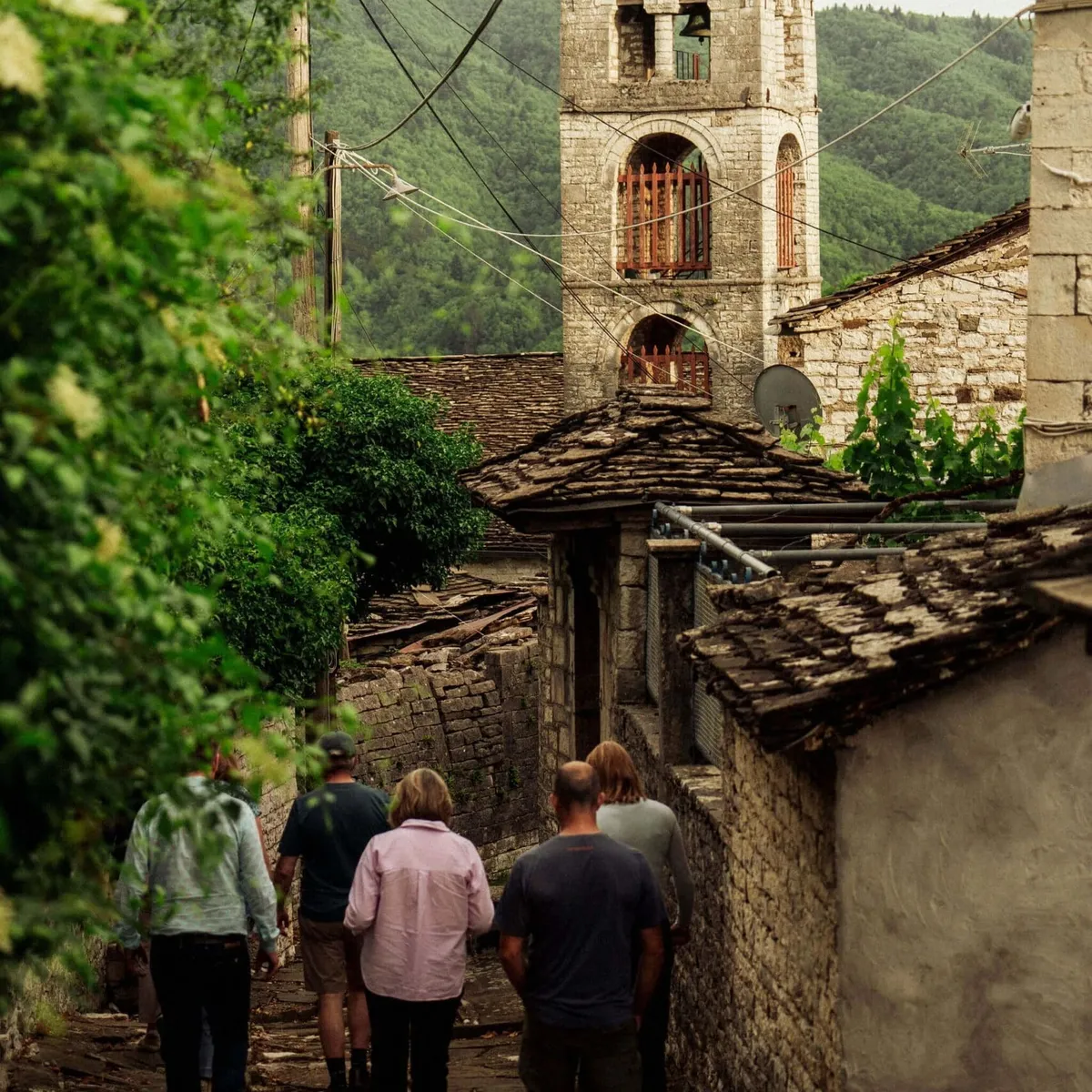Slow Cyclist walking through the traditional stone village of Dilofo in Zagori, Greece.