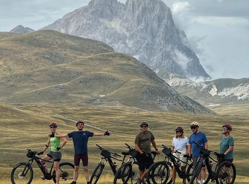 A group of six Slow Cyclists on their bikes, stopping for a break in the mountains of Abruzzo