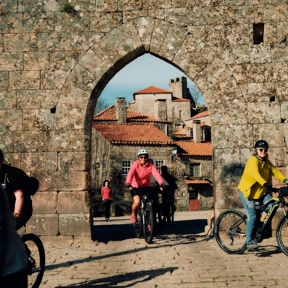 Cycling in Portugal, through an archway in the fortified village of Sortelha in Portugal's Coa Valley