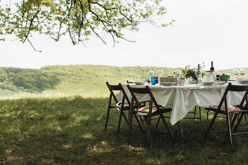 A picnic table under a tree in Transylvania, set for lunch on a Slow Cyclist journey.