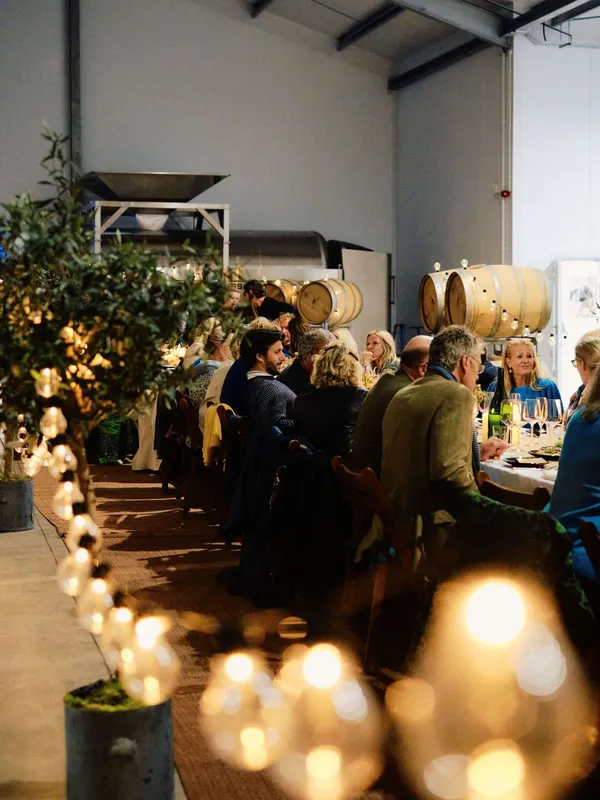The Slow Table guests enjoying a Syrian dinner among the tanks of The Grange's wine room