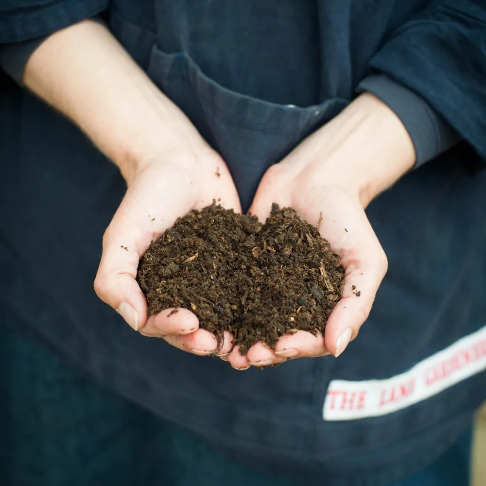 Hands holding soil as part of The Land Gardeners' soil analysis