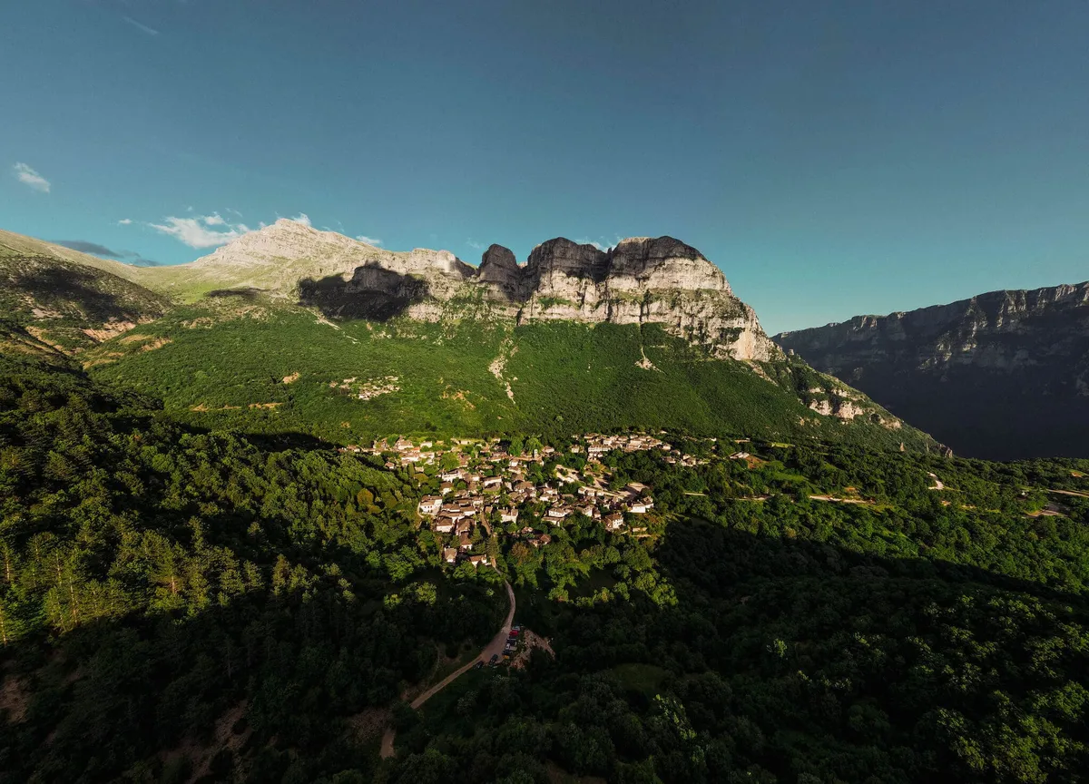 A view of mountains and traditional stone villages in Zagori, Greece.