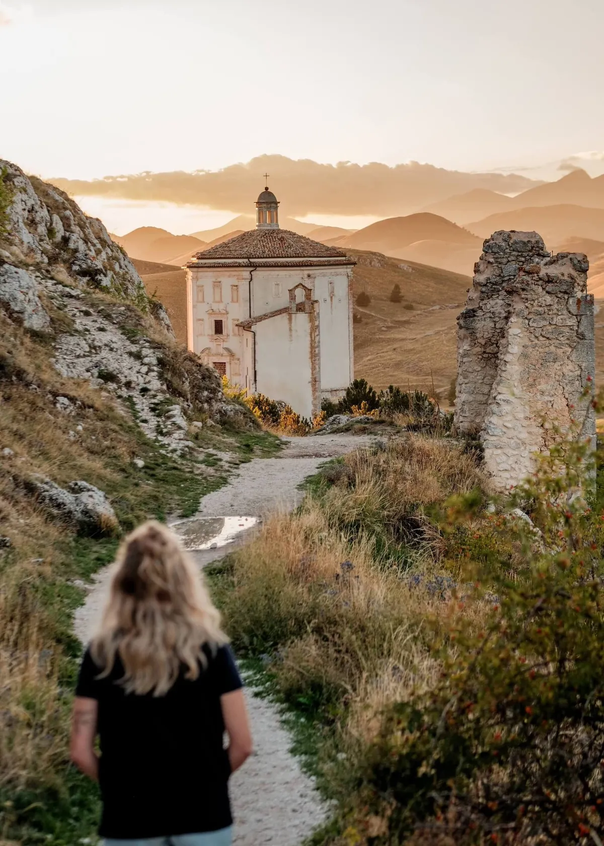 Woman walking along hill path to the church of Santa Maria, Abruzzo, Italy