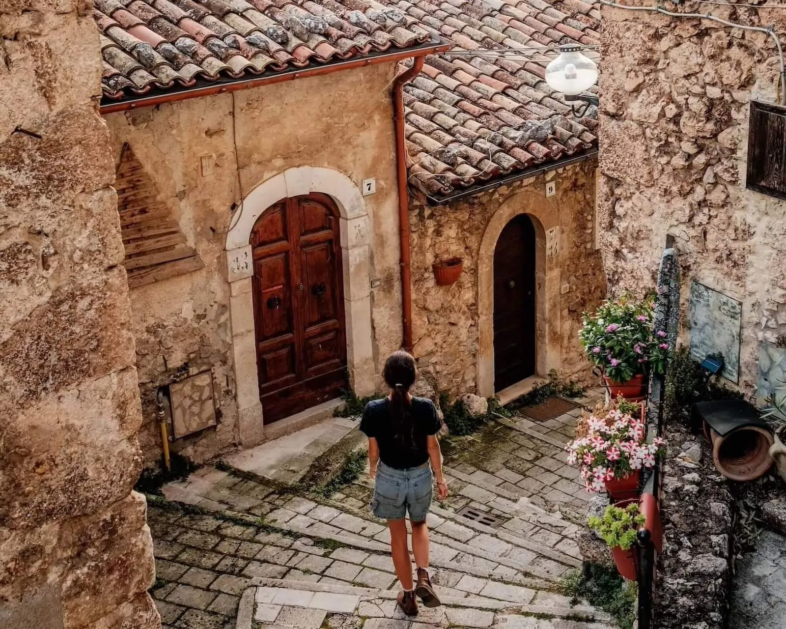 Woman walking down cobbled street, sextantio le grotte della civita, Abruzzo,Italy