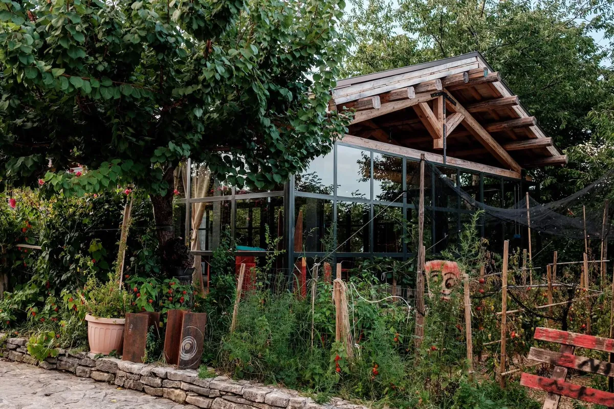 Wood and glass greenhouse surrounded by greenery, Case Catalano, Abruzzo, Italy