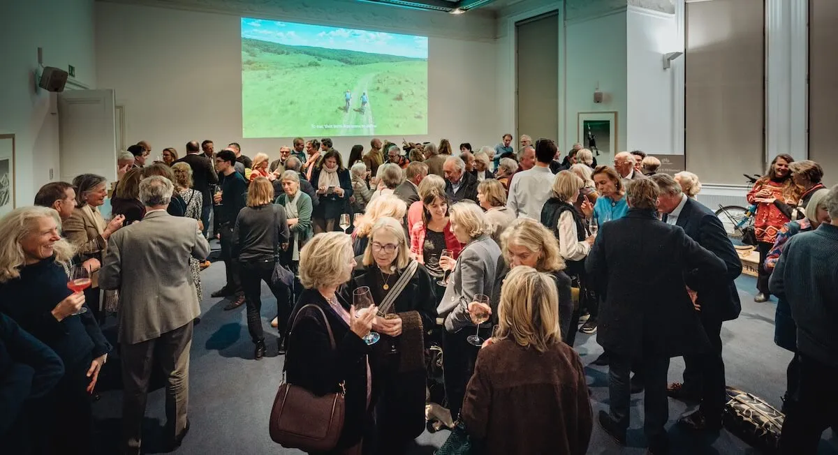 crowds of guests at 10 year anniversary party with brand film in background