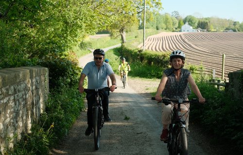 Guests cycling along road, White Heron, Herefordshire, UK